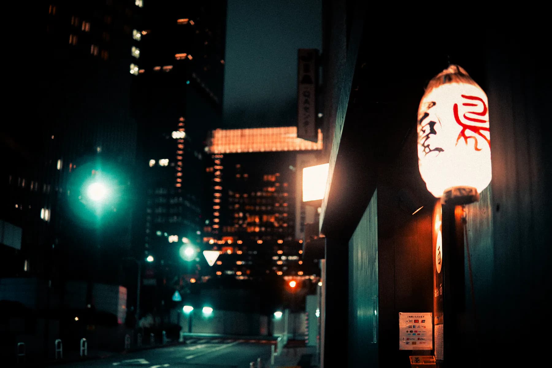 A glowing Japanese restaurant lantern on a dark Tokyo street