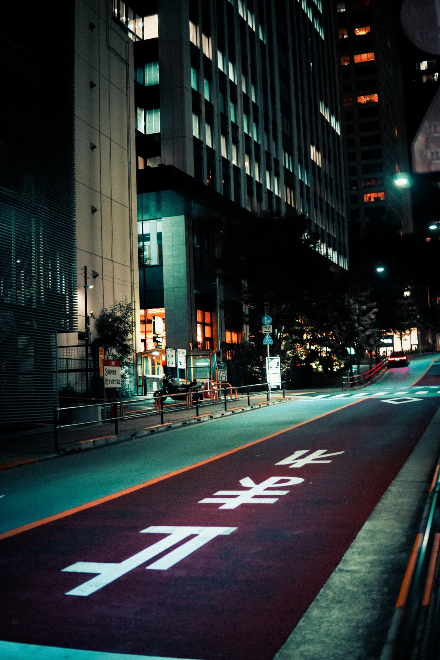 A Tokyo street lane at night with Japanese road markings